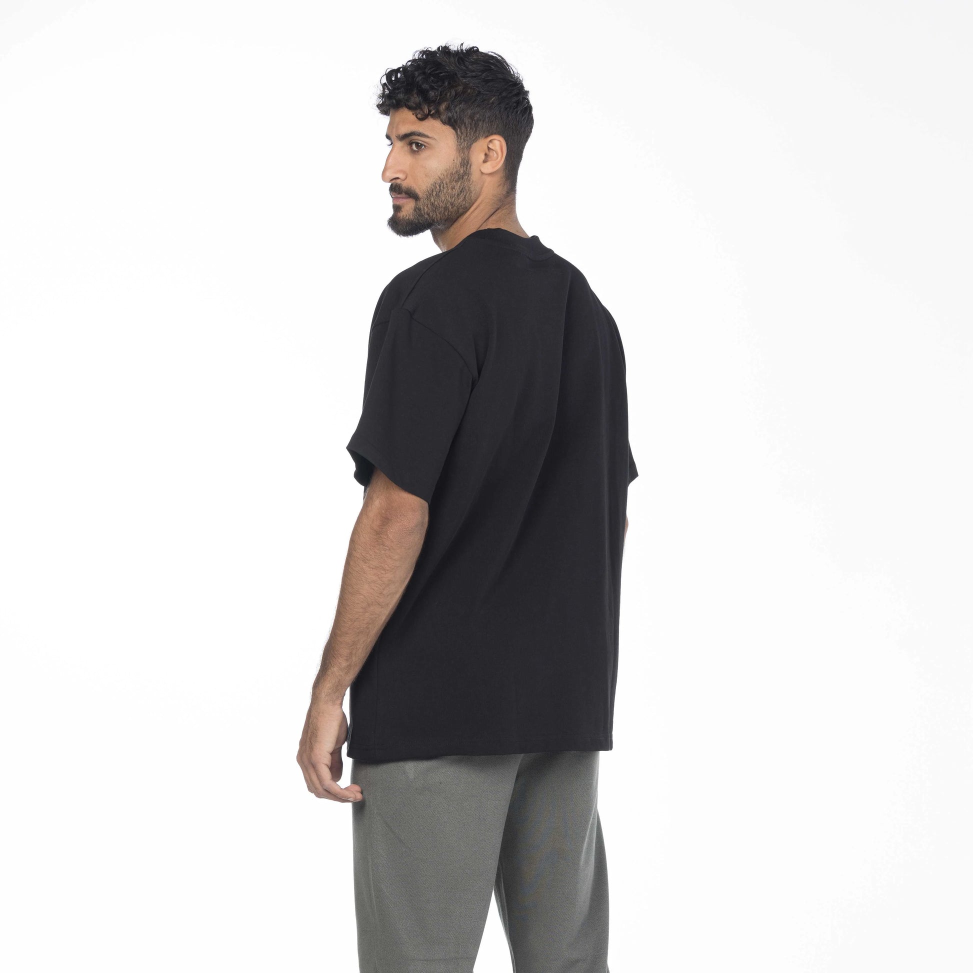 Male model wearing a black premium cotton shirt with a drop shoulder fit by Intersect Collection